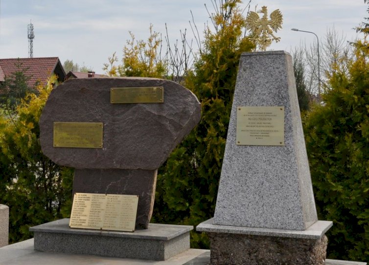 Pomnik skłdający się z dwóch części, jedna  pionowy blok kamienny, zwęzający się do góry, na nim metalowy orzeł, drugi kamień na cokole, na nim dwie tablice, pod nim jedna większa